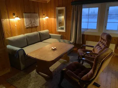 a living room with a couch and a table and chairs at Tørresvangen in Tynset
