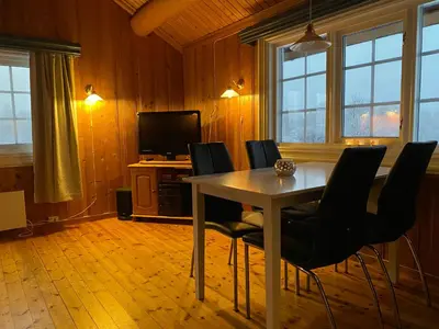 a dining room with a table and chairs at Tørresvangen in Tynset