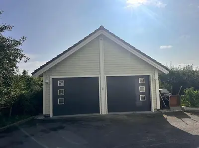 a garage with two large garage doors on it at Stor enebolig Trondheim syd in Trondheim