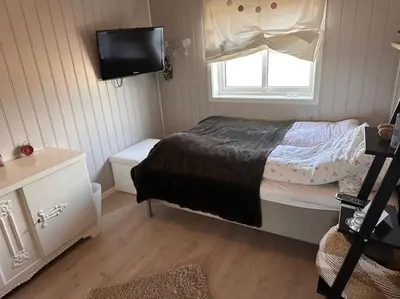 a small bedroom with a bed and a television at Stor enebolig Trondheim syd in Trondheim