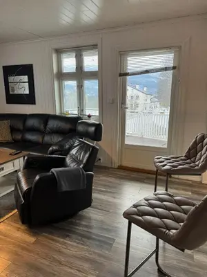 a living room with a black leather couch and chairs at Prime location, 400 m from the town centre in Vossevangen