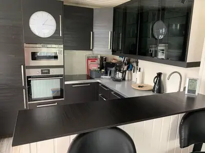 a kitchen with a counter top with a clock on the wall at Prime location, 400 m from the town centre in Vossevangen