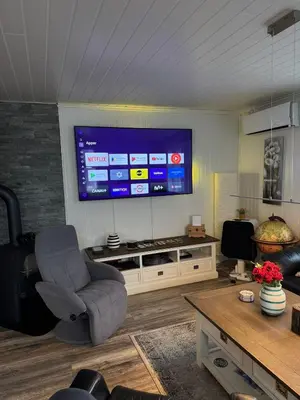 a living room with a chair and a large television at Prime location, 400 m from the town centre in Vossevangen