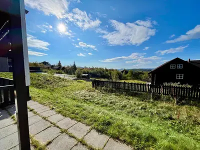 a field with a house and a fence at Spacious Stay With 3 Bedrooms And 2 Baths in Beitostøl