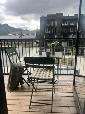 a table and chairs on a balcony with a view of the water at Helt ny leilighet ski in- ski out i Hemsedal in Hemsedal