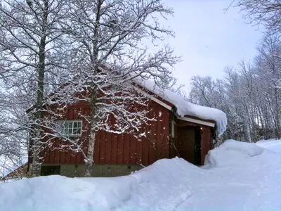 a red barn with snow on the roof at Charming Cabin Ski-In Access And Pet Friendly in Beitostøl