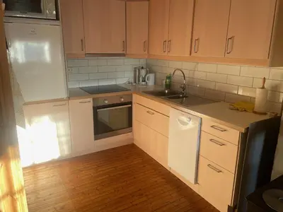 a kitchen with white appliances and wooden cabinets at Charming Cabin Ski-In Access And Pet Friendly in Beitostøl