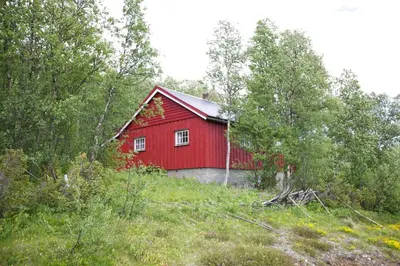 a red barn in the middle of a field at Charming Cabin Ski-In Access And Pet Friendly in Beitostøl