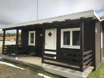 a black tiny house with a porch at Granmo Camping in Oppdal