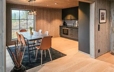 a kitchen and dining room with a table and chairs at Stunning Home In Vinje With Wifi in Trovatn
