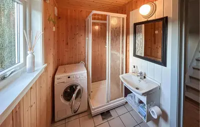 a bathroom with a washing machine and a sink at Cozy Home In Nerlandsøya Grunnkrets in Kvalsvik