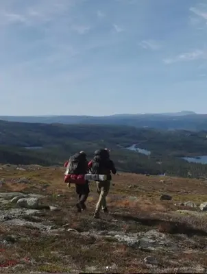 a couple of people walking up a hill with backpacks at Koselig hytte sentralt på Norefjell, ski in & out in Surteberg