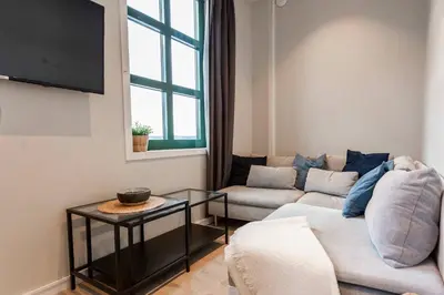 a living room with a couch and a tv at Beautiful Harbour Apartment With French Balcony in Bergen
