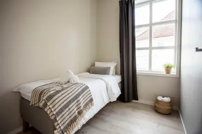 a bedroom with a bed and a window at Beautiful Harbour Apartment With French Balcony in Bergen