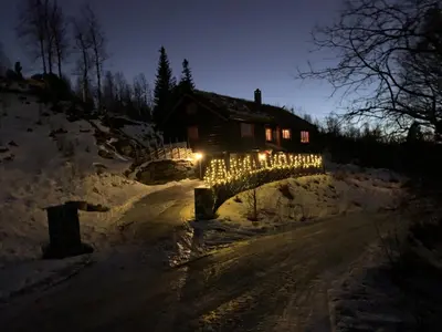 a bridge with christmas lights in front of a house at Spacious cabin with beautiful Geilo views in Geilo