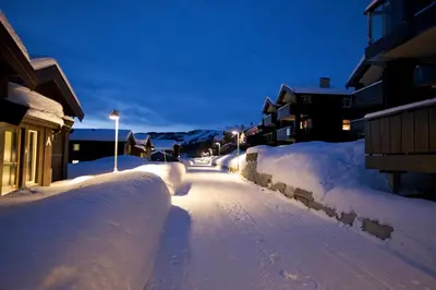 a street covered in snow at night with buildings at Bright 2-Bedroom With Terrace And Fireplace in Beitostøl