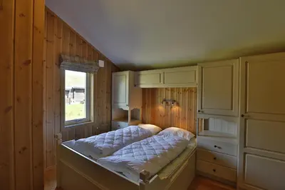 a bed in a room with a window and cabinets at Bright 2-Bedroom With Terrace And Fireplace in Beitostøl