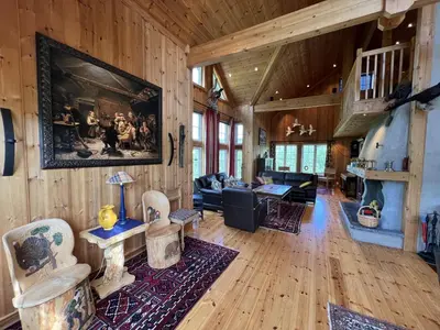 a living room with wood floors and a large painting on the wall at Grand Log Cabin With Fireplace And 12-14 Beds in Beitostøl