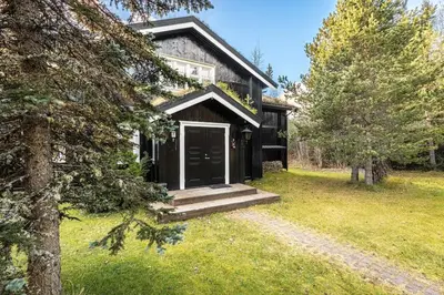 a house with a black door in a yard at Hemsedal Mountain Retreat in Hemsedal