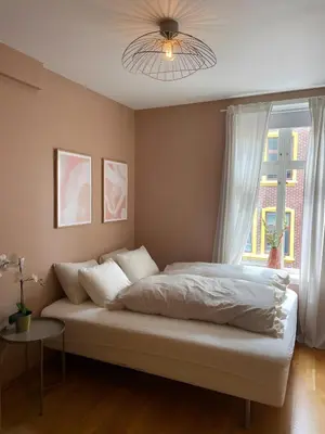 a bedroom with a bed with a ceiling fan and a window at Lovely 3-room gem in the heart of Bergen City in Bergen