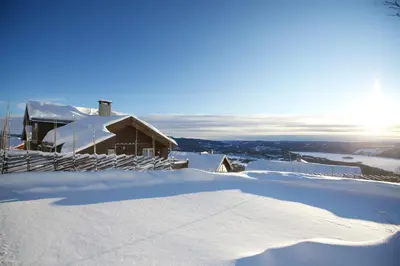 a snow covered house on top of a mountain at Apartment By Cross-Country And Alpine Slopes in Beitostøl