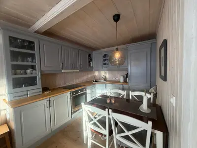 a kitchen with white cabinets and a table and chairs at Apartment By Cross-Country And Alpine Slopes in Beitostøl