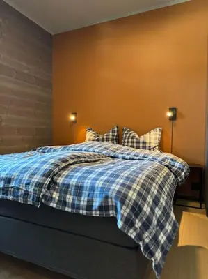 a bedroom with a blue and white bed with pillows at Riddertunets stilfulle in Beitostøl
