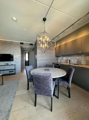 a dining room with a table and chairs in a kitchen at Riddertunets hygge in Beitostøl
