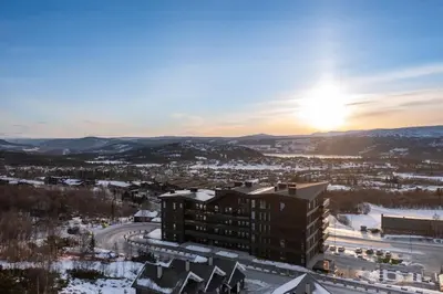 a view of a building with the sunset in the background at Riddertunets hygge in Beitostøl