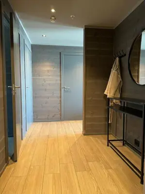a room with a wooden floor and a closet with a mirror at Riddertunets hygge in Beitostøl