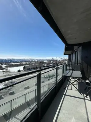 a balcony with a chair and a view of a highway at Riddertunets utsikt til Mugnetind in Beitostøl