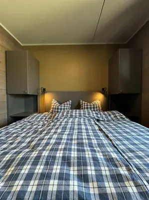 a bedroom with a blue and white bed with two pillows at Riddertunets utsikt til Mugnetind in Beitostøl