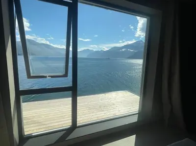 a window with a view of the water and mountains at Amazing View in Stranda