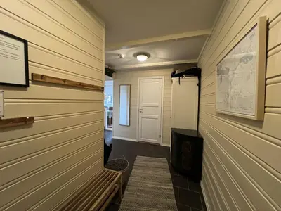 a hallway with wood paneled walls and a door at Bright, Open Apartment In Beitostølen in Beitostøl