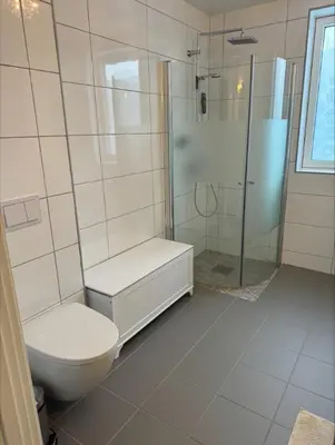 a white bathroom with a toilet and a shower at Skyttarbakken 57 in Heimdal