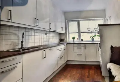 a kitchen with white cabinets and a large window at Skyttarbakken 57 in Heimdal