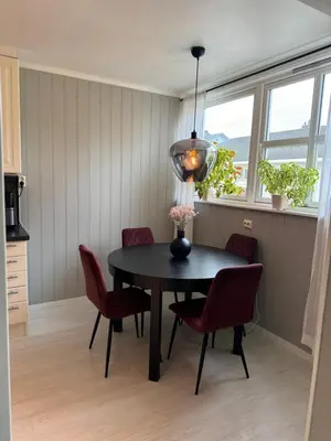 a dining room with a black table and red chairs at Leilighet nært Granåsen skisenter in Trondheim