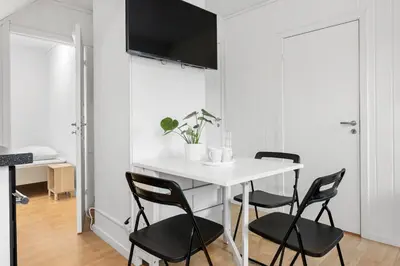 a dining room with a white table and black chairs at City center apartment with teracce in Bergen