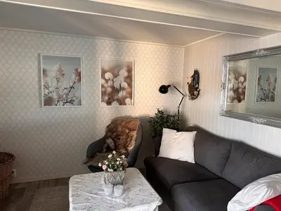a living room with a couch and a table at Det lille huset i Slipveien in Bud