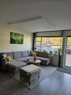 a living room with a couch and a table at Exclusive three-story villa near the ski center in Trondheim