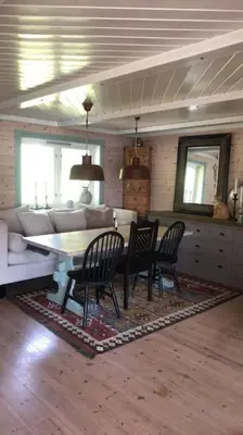 a living room with a table and chairs and a couch at PARADISET - a beautiful pearl 1,45 minutes from Trondheim in Surnadal
