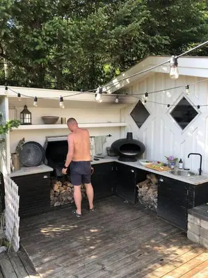a man standing in front of an outdoor kitchen at PARADISET - a beautiful pearl 1,45 minutes from Trondheim in Surnadal