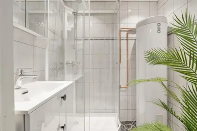 a bathroom with a shower and a toilet and a sink at Dinbnb Apartments l Free Parking l 5 Min From Torget l Nearby Coast I Newly Furnished in Bergen