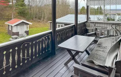 a porch with a wooden bench and a table at Lovely Home In Lena With Wifi