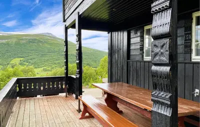 a wooden bench on the porch of a house at Nice Home In Oppdal With Sauna in Oppdal