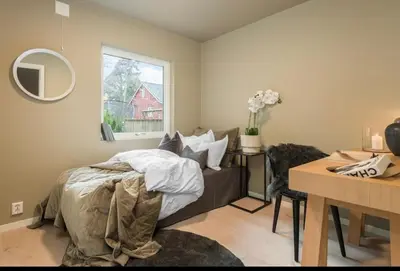 a bedroom with a bed and a desk and a window at Flott bolig til VM! Gåavstand in Trondheim