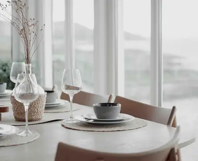 a table with two wine glasses and a bowl and a plate at Paradise by the Seaside in Hitra