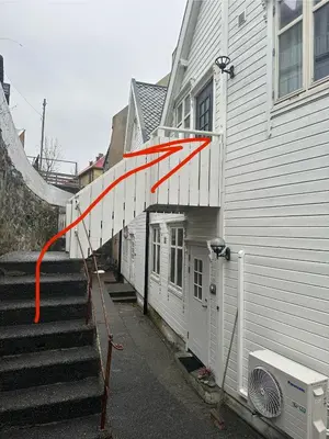 a red arrow on the side of a building at Historical house with view and separate entrance in Ålesund