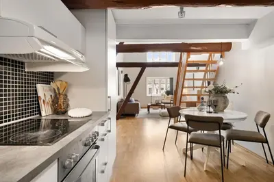 a kitchen with a table and a dining room at Charming Loft, High Ceiling !Modern & Central, Free private Parking 7 min walking ! in Trondheim