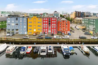 a group of boats parked in a marina in a city at Charming Loft, High Ceiling !Modern & Central, Free private Parking 7 min walking ! in Trondheim